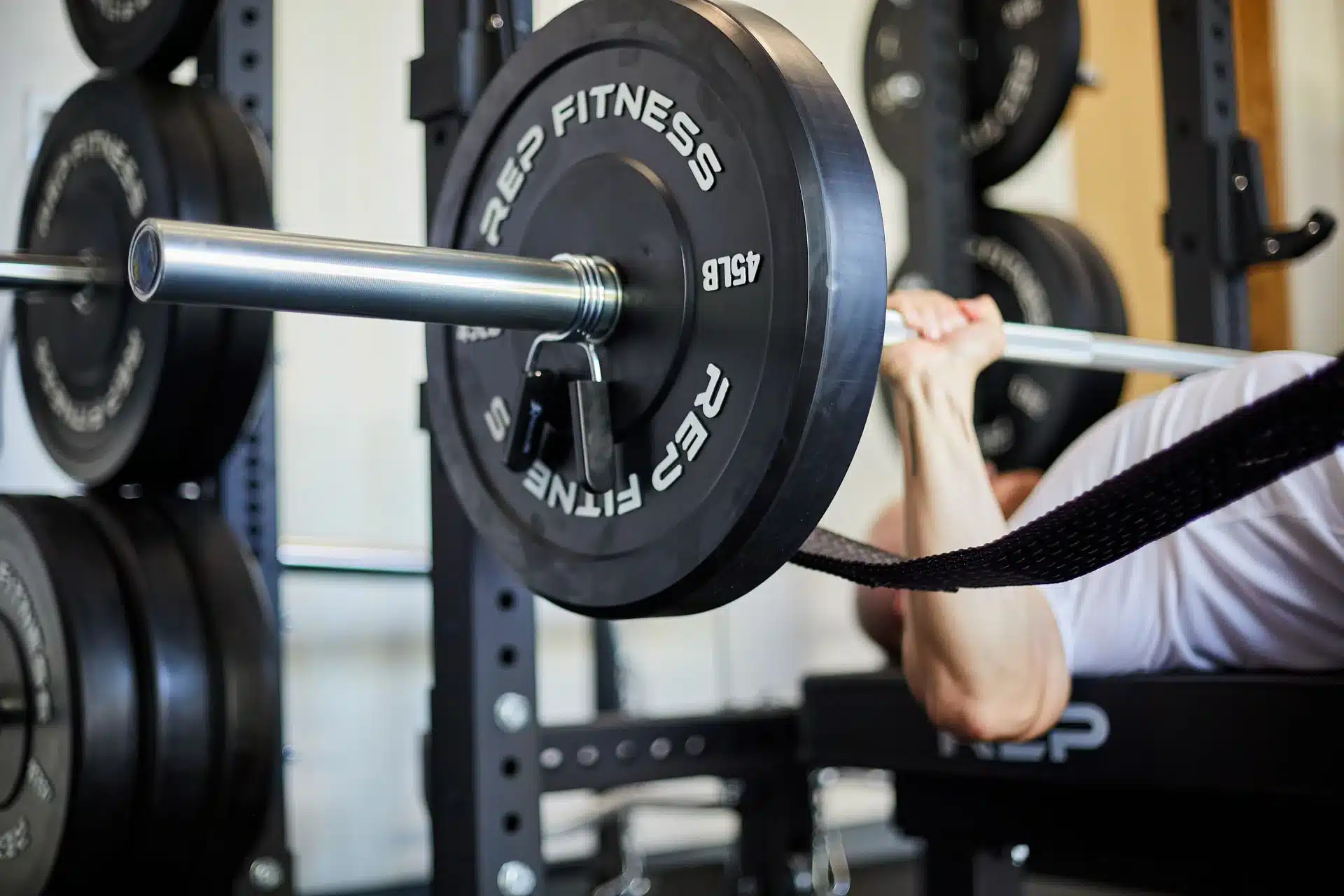 man bench pressing with rep fitness rubber bumper plates