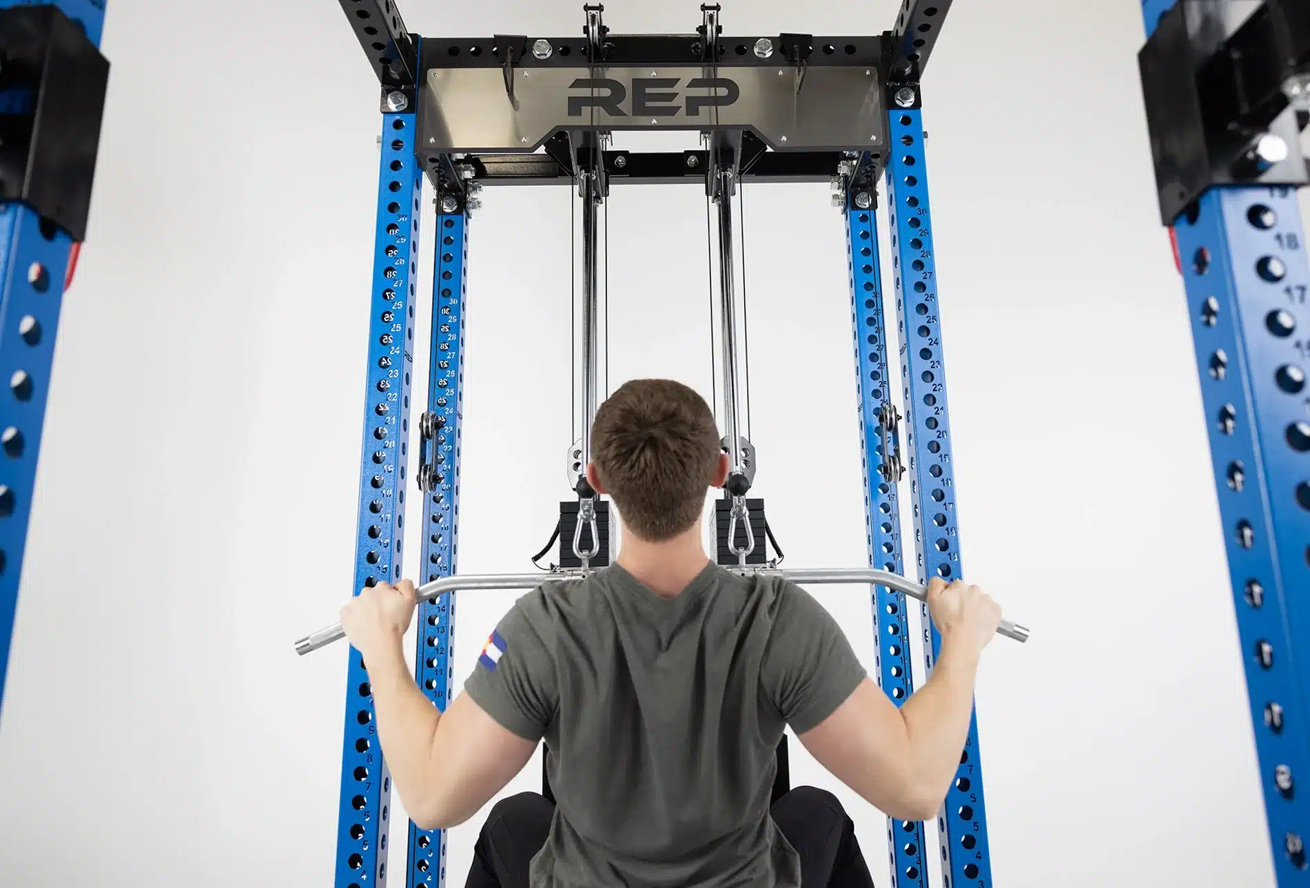 man doing lat pulldown inside rack
