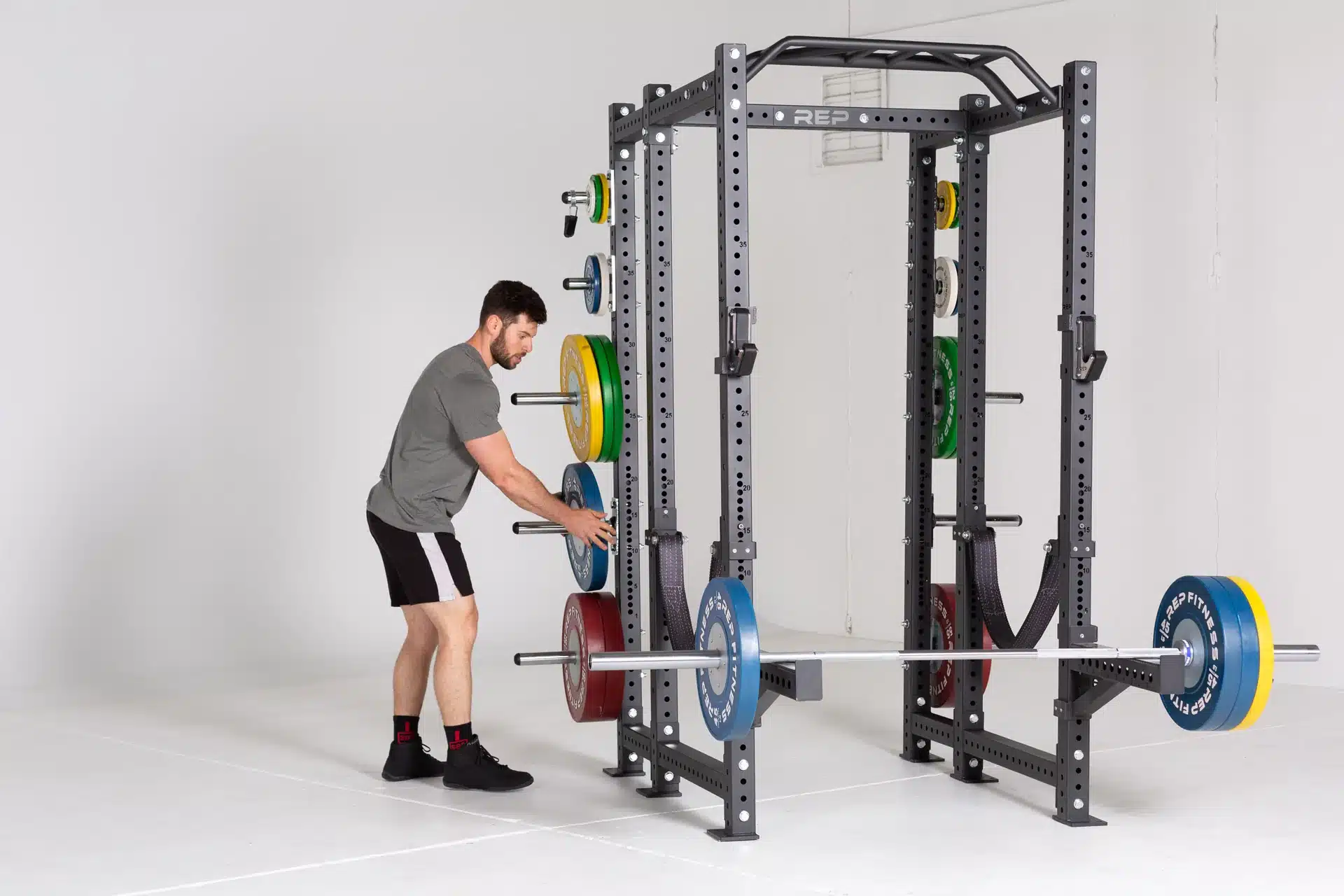 man unracking weight to load on power rack