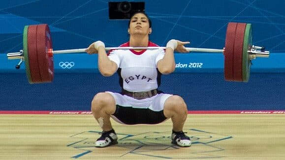 female olympic weightlifter performing a clean with an olympic weightlifting barbell