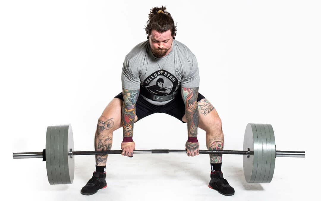 man doing a sumo deadlift with deadlift bar