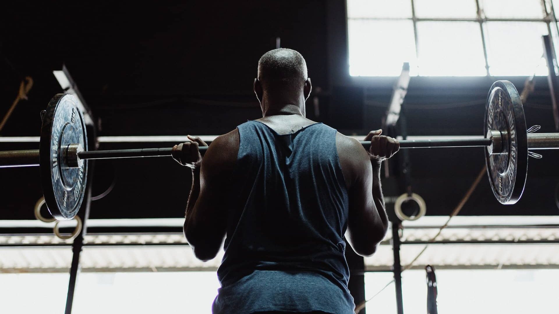 man in the starting position for the overhead press using a multipurpose bar