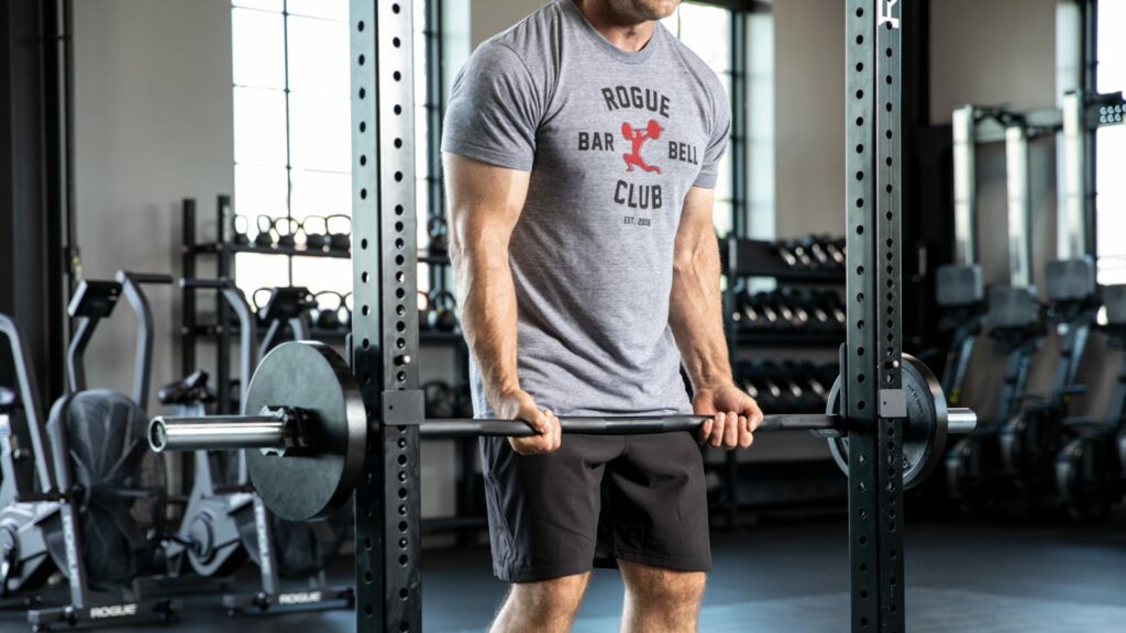 man unracking rogue curl bar