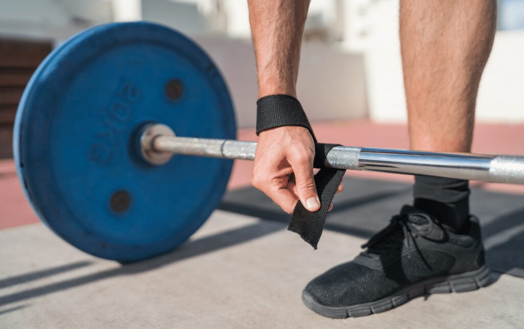 man setting up straps to deadlift