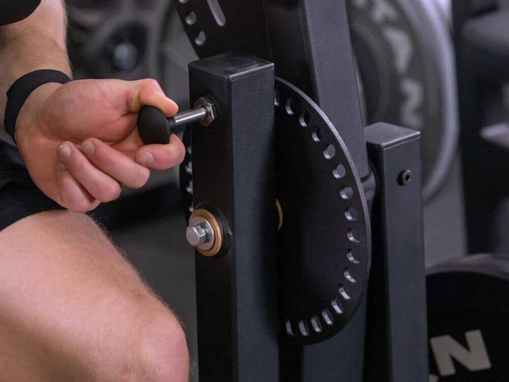 man adjusting loading arm on machine