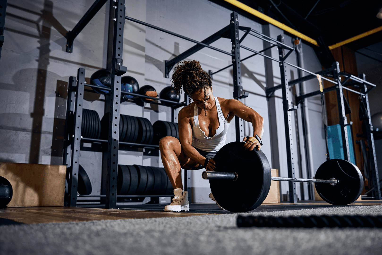 woman showing how to load a barbell on the ground