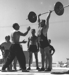 man lifting barbell over his head