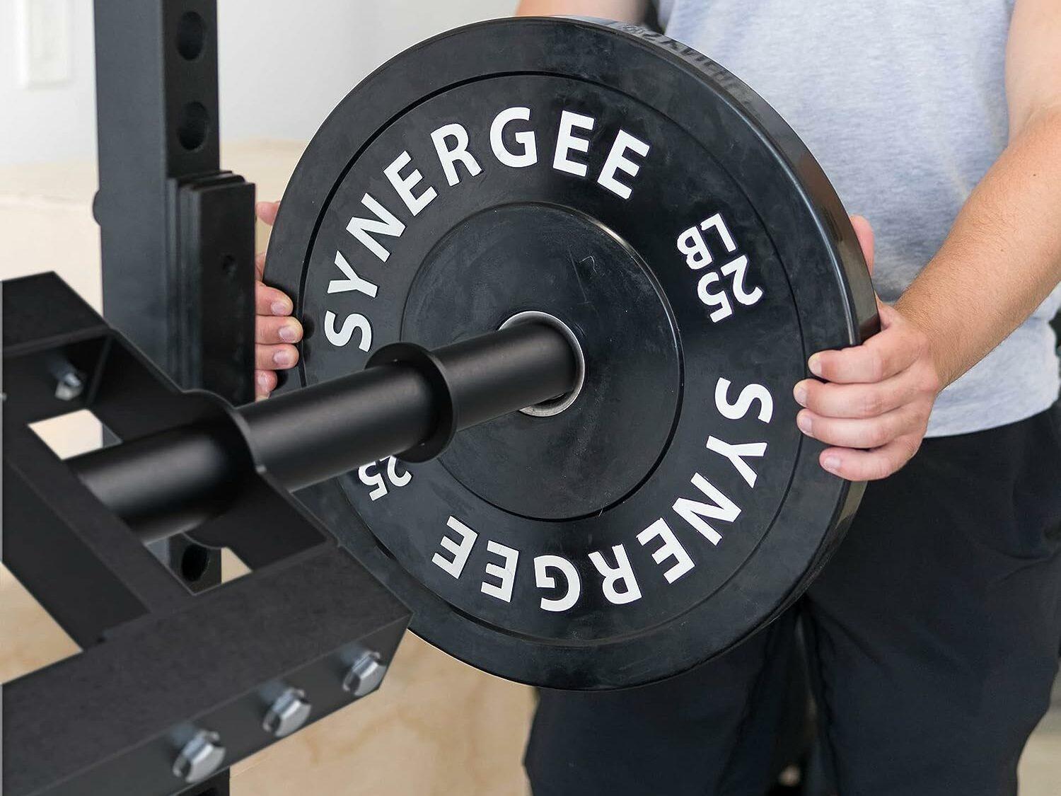 man loading black bumper plate onto bar
