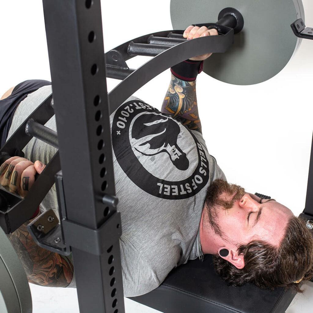 man benching with nemesis bar