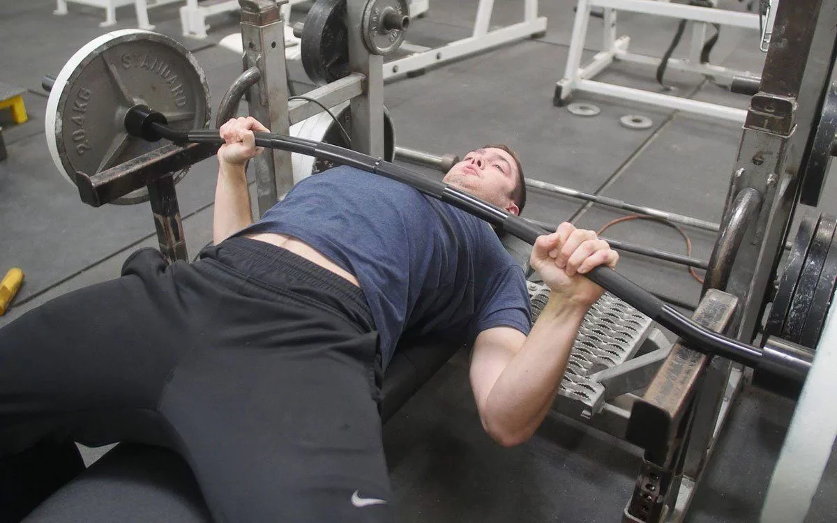 man benching with a buffalo bar