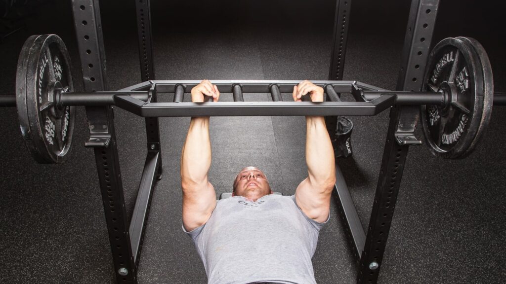 man benching with swiss bar