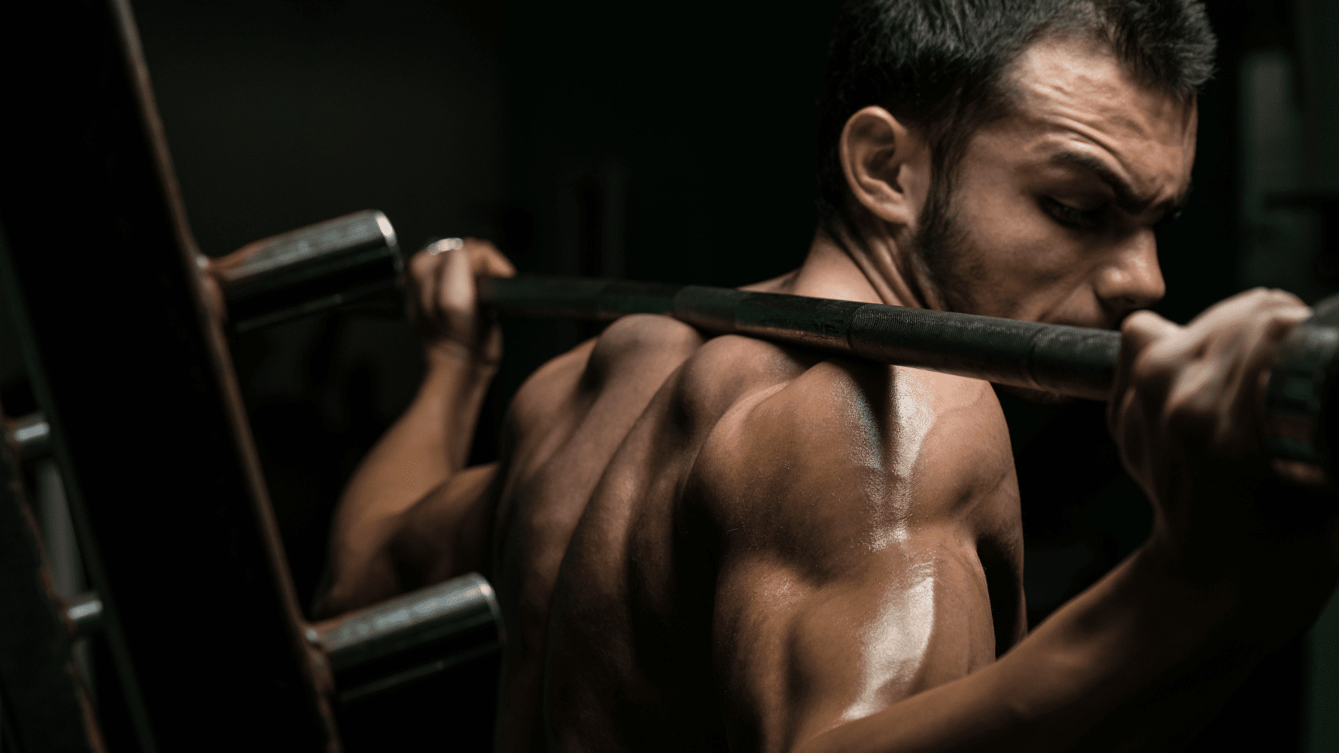 man looking at barbell on back