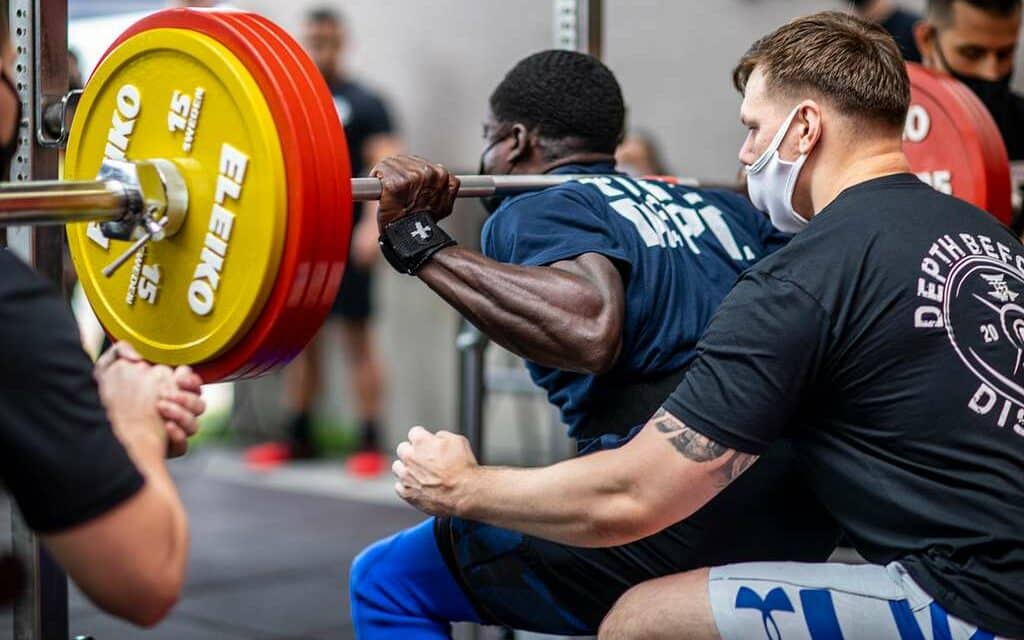 man squatting with a powerlifting barbell