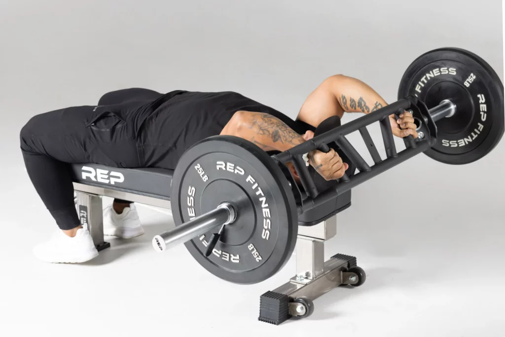 man doing skull crushers with swiss bar