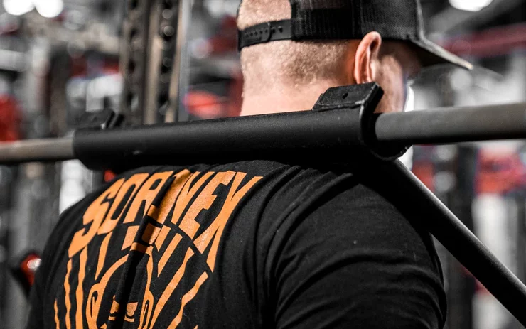 man using top squat on his upper back
