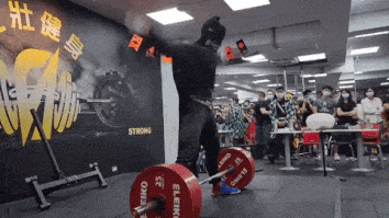 man wearing homemade batman costume deadlifting a bunch of weight