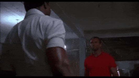 arnold and carl weathers gripping each others hands and