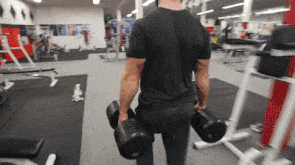 man doing farmer walks through gym
