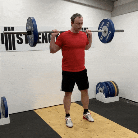 man doing farmer walks through gym