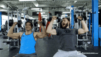 arnold and carl weathers gripping each others hands and flexing