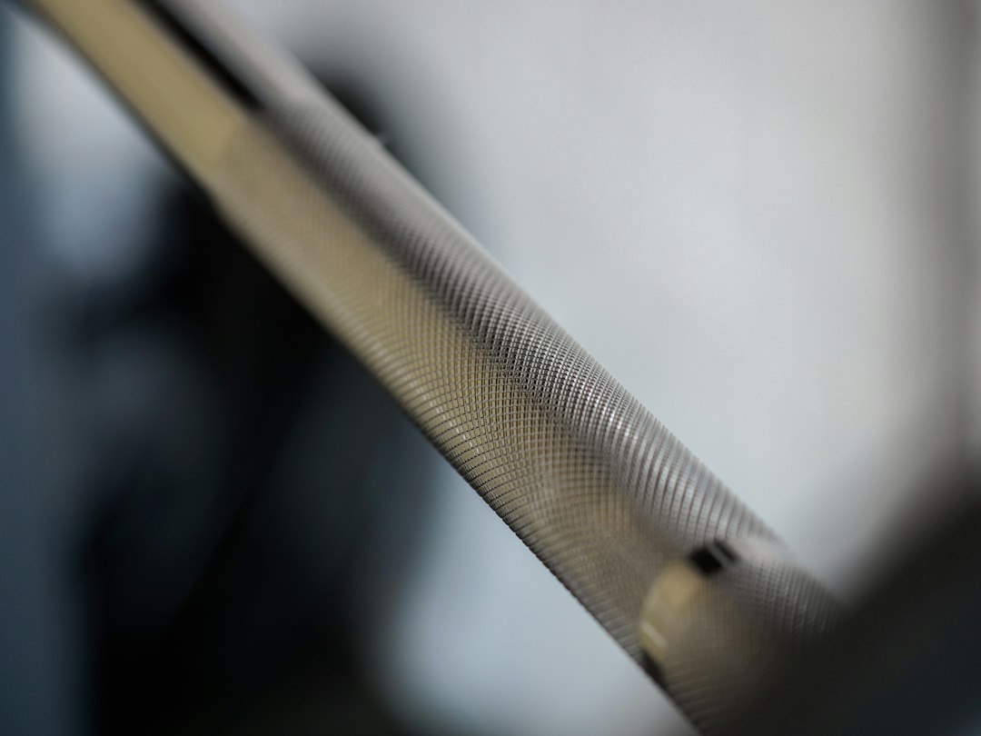 Close-up of a barbell shaft and knurling in a gym